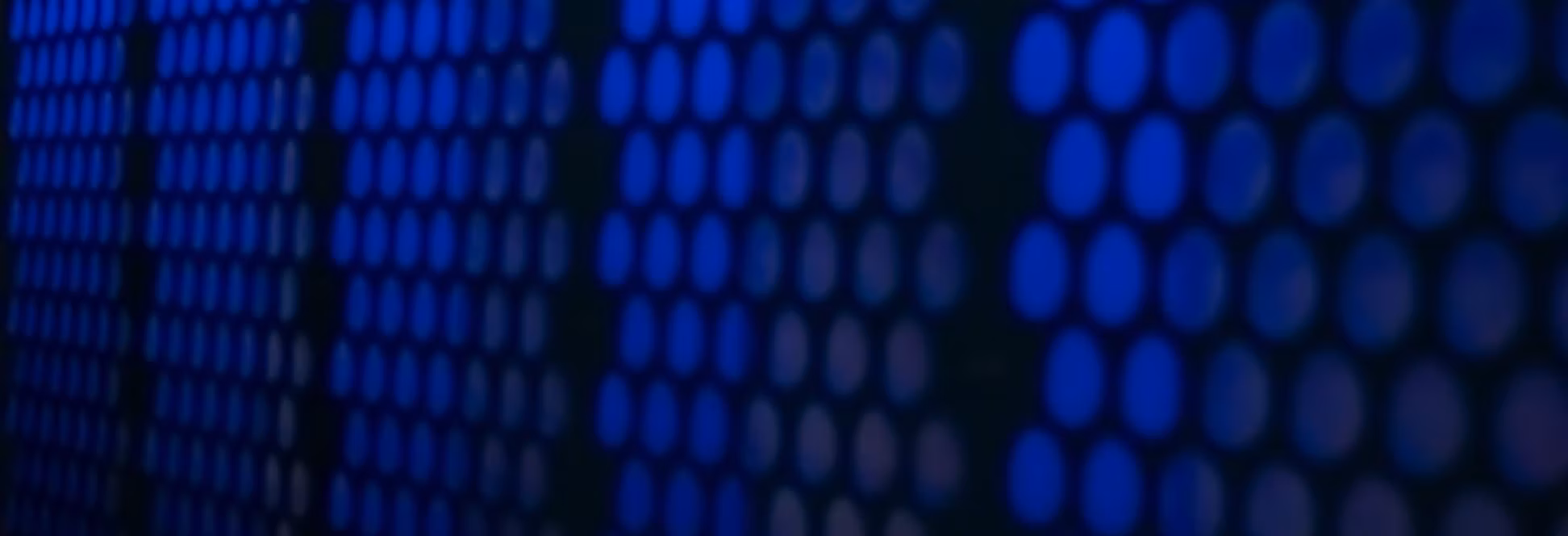 Blue lights behind metal plates with holes in it.